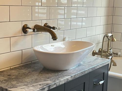 a bathroom with a white bowl sink on a counter at LLU Homes in Westport