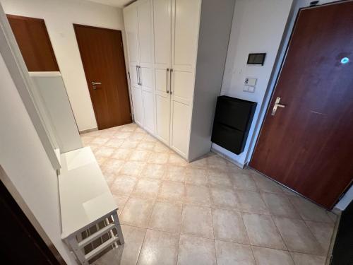 a small kitchen with white cabinets and a tiled floor at Mattioliho Apartment in Prague