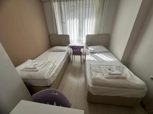 two beds in a small room with a window at Safranbolu apartments in Karabük