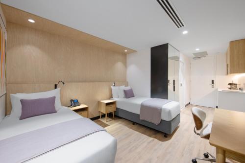 a hotel room with two beds and a kitchen at Haberfield Hotel in Sydney