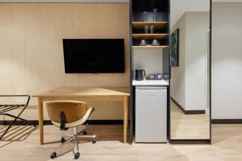a room with a desk with a television and a chair at Haberfield Hotel in Sydney