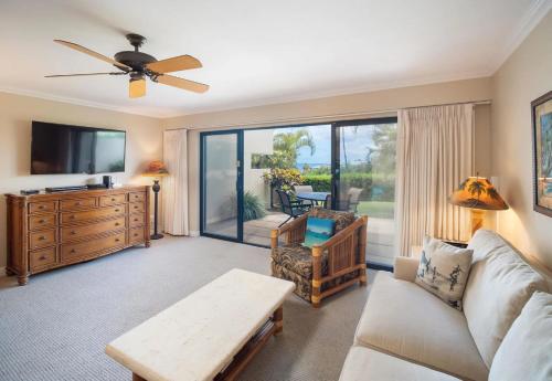 a living room with a couch and a tv at Ho'omaha - Serene Kihei Condo in Maui Kamaole for Ocean Views and Relaxation in Wailea
