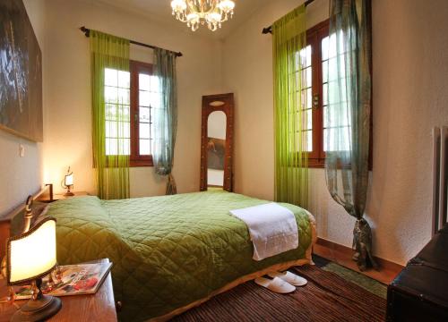 アラコバにあるLilea Apartmentsのベッドルーム1室(緑のベッド1台、窓2つ付)