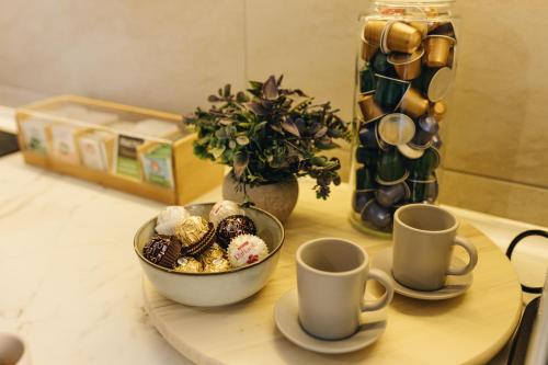 a table with a bowl of food and two cups at Apartman Premijer 2 in Čukarica