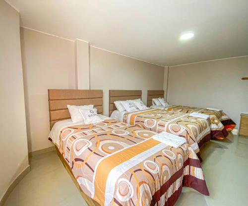 two beds sitting next to each other in a room at QAIPU HOTEL in Puquio