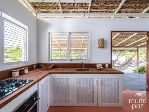 a kitchen with a sink and two windows at Casa Mais Amor in Atins