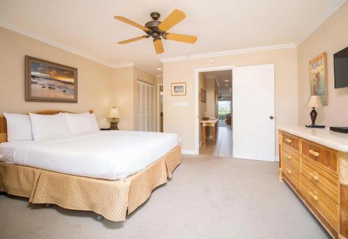a bedroom with a bed and a ceiling fan at Ho'omaha - Serene Kihei Condo in Maui Kamaole for Ocean Views and Relaxation in Wailea