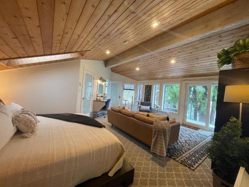 a bedroom with a bed and a couch at Tyee Beach Oasis Bed and Breakfast in Nanoose Bay