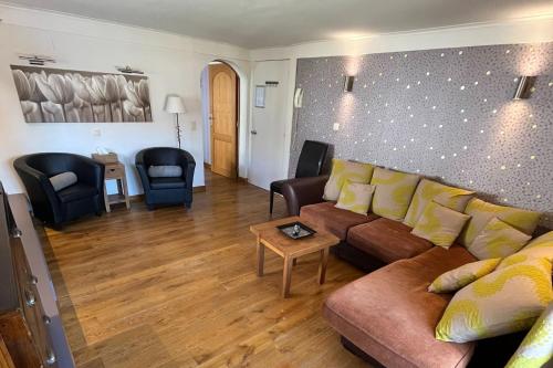 a living room with a couch and a table at La Fontaine du Sabotier in Awenne