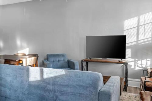 a living room with a blue couch and a flat screen tv at Beautiful Rehabbed Unit in Shaw Community 4228a in Tower Grove