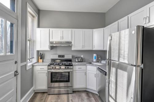 a kitchen with white cabinets and a stainless steel refrigerator at Beautiful Rehabbed Unit in Shaw Community 4228a in Tower Grove
