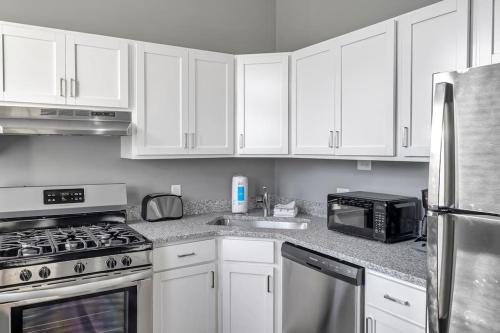 a kitchen with white cabinets and a stove and a microwave at Beautiful Rehabbed Unit in Shaw Community 4228a in Tower Grove