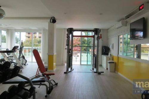 a gym with treadmills and chairs in a room at o MELHOR DA PRAIA BRAVA !!! in Itajaí