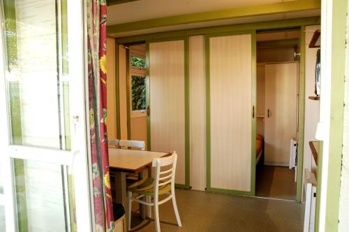 a dining room with a wooden table and chairs at Camping As Cancelas in Santiago de Compostela
