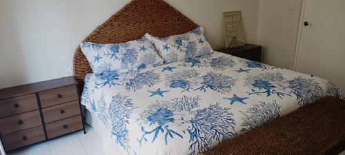 a bedroom with a bed with a blue and white comforter at A pie de mar en zona hotelera, 1BR condo In Monarca Ixtapa, no pagas brazalete in Ixtapa
