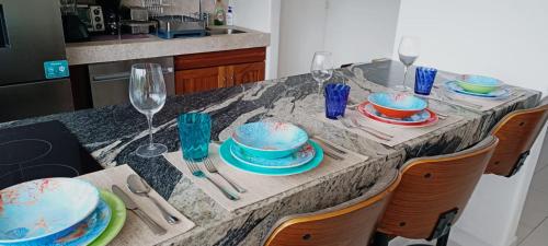 a table with blue cakes and plates and wine glasses at A pie de mar en zona hotelera, 1BR condo In Monarca Ixtapa, no pagas brazalete in Ixtapa