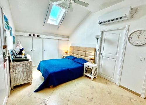 a bedroom with a blue bed and a clock on the wall at Sapphire Penthouse in Cupecoy