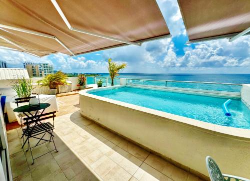 a swimming pool with a view of the ocean at Sapphire Penthouse in Cupecoy