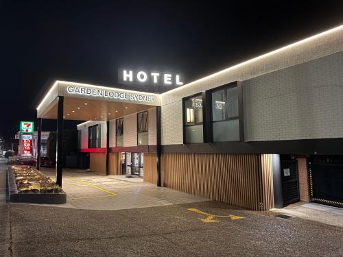a hotel building at night with a sign on it at Garden Lodge Sydney Hotel in Sydney
