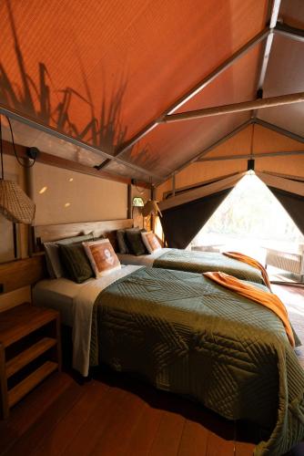 a bedroom with two beds in a tent at Mitchell Falls Wilderness Lodge in Camp Creek
