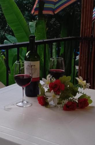 a bottle of wine and two glasses of red wine at Condominio Coco Marindo #34 in Coco