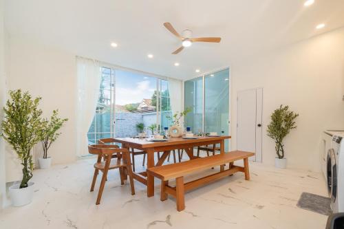 a dining room with a wooden table and benches at Seven Heaven Patong Villa in Patong Beach