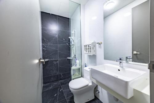 a bathroom with a sink and a toilet and a mirror at #12Georgetown Luxury Suite with Rooftop Pool in George Town