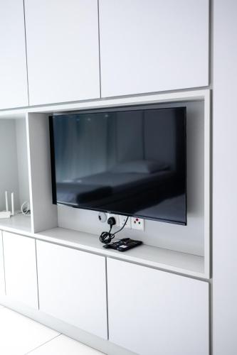 a flat screen tv on a white cabinet at #12Georgetown Luxury Suite with Rooftop Pool in George Town