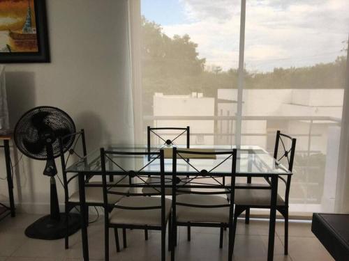 a glass table and chairs in a room with a window at Hermoso conjunto residencial con piscina in Balastera