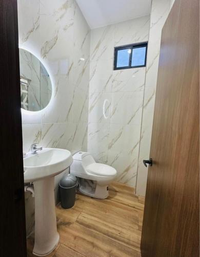 a white bathroom with a sink and a toilet at Departamento vacacional La Gaudelia in Crucita