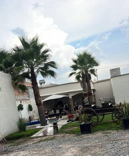 a building with palm trees in front of it at Departamento con alberca in San José Iturbide