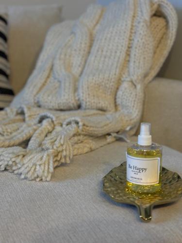 a bottle of oil sitting on a bed with a blanket at Departamento con alberca in San José Iturbide
