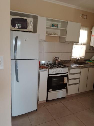 a kitchen with a white refrigerator and a stove at Rivera Este in Colón