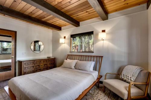 a bedroom with a bed and a chair at Modern Retro Tahoe Chic Chalet in Tahoe City