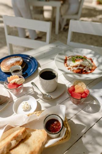 uma mesa coberta com pratos de comida e chávenas de café em Hotel Puerto Holbox Beach Front em Ilha Holbox