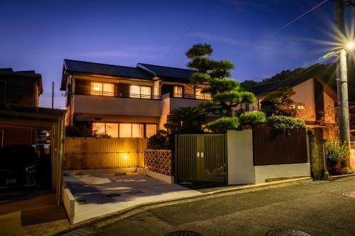 a house with a gate and a fence at 中山宿 Nakayama Villa 車移動に便利な広島高速すぐそば165平米の贅沢空間 無料駐車場に充電スタンド有り supported by COCOSTAY in Hiroshima