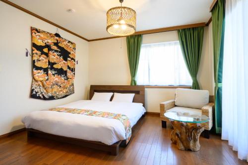 a bedroom with a bed and a table and a chair at 中山宿 Nakayama Villa 車移動に便利な広島高速すぐそば165平米の贅沢空間 無料駐車場に充電スタンド有り supported by COCOSTAY in Hiroshima