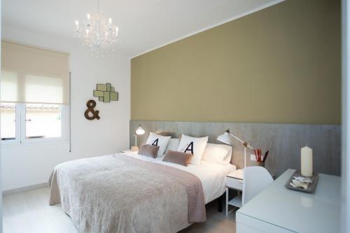 1 dormitorio con cama blanca y lámpara de araña en Charming & Quiet Park Guell Apartment, en Barcelona