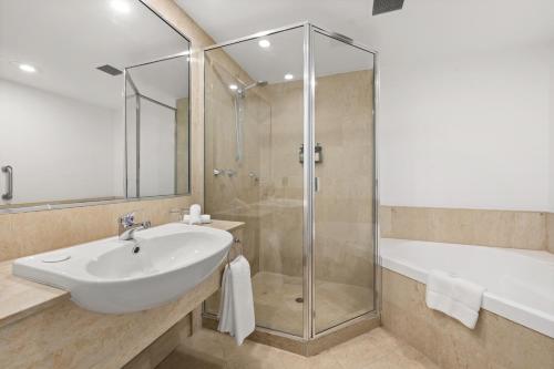 a bathroom with a white sink and a shower at Crowne Plaza Surfers Paradise by IHG in Gold Coast