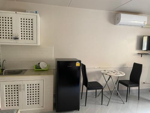 a kitchen with a black refrigerator and a table at Dailyroom C3,C4by Anna in Nonthaburi