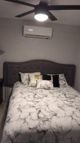 a bedroom with a large bed with a ceiling fan at Praderas in Los Mochis