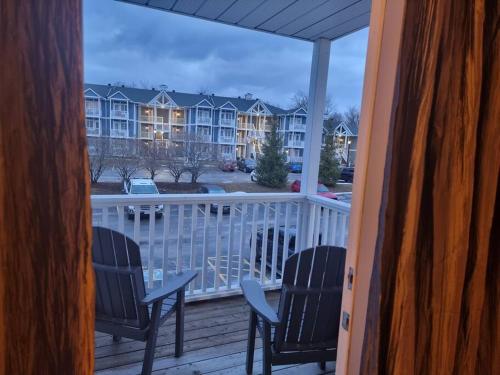 a balcony with chairs and a view of a building at Country Retreat Horseshoe Valley in Shanty Bay