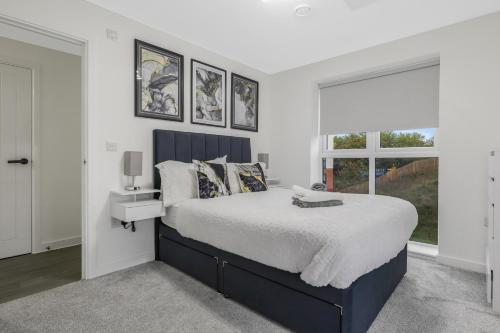 a bedroom with a large bed and a window at Beaver Stays- Coventry Serviced Apartment in Coventry