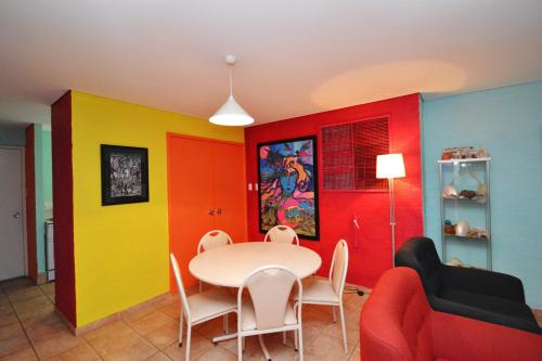 ein Esszimmer mit farbenfrohen Wänden sowie einem Tisch und Stühlen in der Unterkunft Riverview Holiday Apartment 25 - Kalbarri, WA in Kalbarri