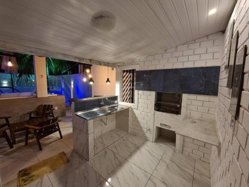 a large kitchen with a counter and a fireplace at Refugio dos Carneiros in Praia dos Carneiros