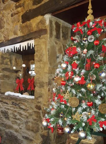 a christmas tree in front of a stone wall at Hotel Rural Palacio de Galceran in Sotiello