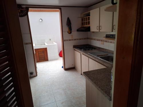 a kitchen with a sink and a door to a room at Finca villa carolina, eje cafetero in La Floresta
