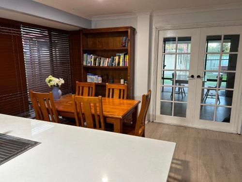 a dining room with a wooden table and chairs at Celia's lovely house in Perth