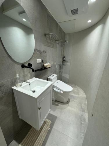 ein Badezimmer mit Waschbecken, Toilette und Spiegel in der Unterkunft Bali Design River View in Bali