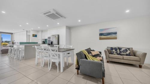 a kitchen and living room with a table and chairs at Waterfront On Market in Merimbula